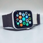 Smartwatch with a dark textured band and colorful app icons on its display, illustrating a smartwatch buying guide