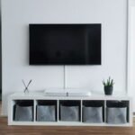 Flat-screen TV mounted on a living room wall above a white media console, illustrating a budget 4K TV buying guide