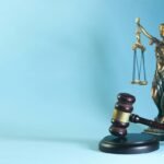 Lady justice statue and gavel on a blue background, illustrating AI regulation around the world